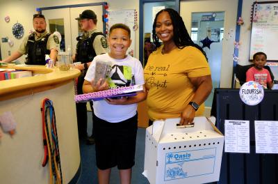 Two people at Regional Animal Services holding a cardboard cat carrier